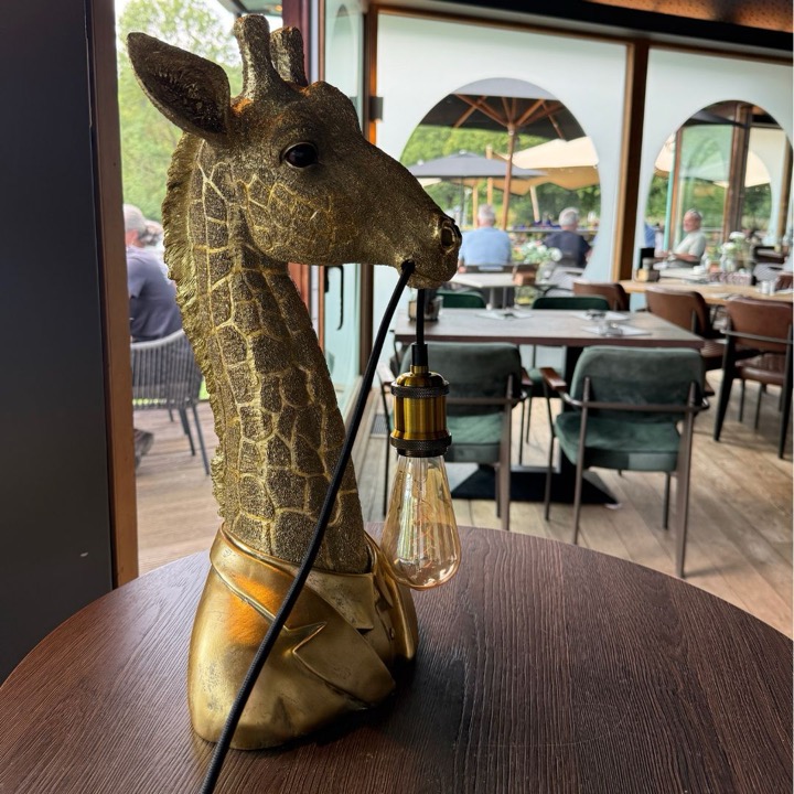 Golden giraffe lamp on a table in the restaurant